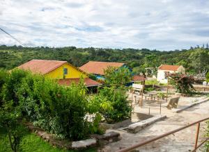 a yellow house in a village with trees at Chalés de Triunfo in Triunfo