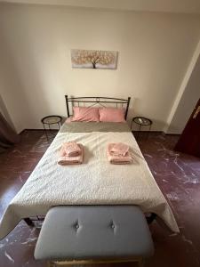 a bedroom with a bed with two pink towels on it at Derveni Nest Apartment in Rodhéa