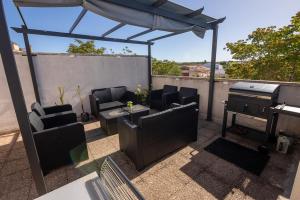 eine Terrasse mit Gartenmöbeln und Grill auf dem Dach in der Unterkunft Hotel Raimblanc in Villargordo del Cabriel