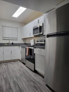 a kitchen with white cabinets and a stainless steel refrigerator at Close to ASU campus in Tempe