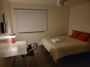 a bedroom with a bed and a table with a lamp at Close to ASU campus in Tempe