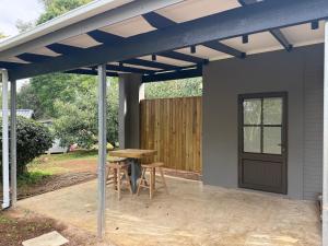 a pergola over a patio with a table and chairs at Avo 1 on 27 Drew in Howick