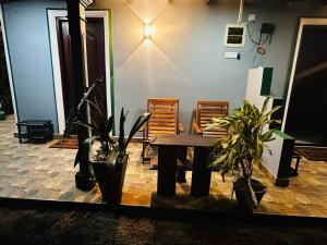 a table and chairs in a room with plants at The Sigiriya Rock Gate Chalet in Sigiriya