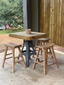 a wooden picnic table with two stools and a bench at Avo 1 on 27 Drew in Howick