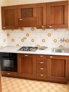 a kitchen with wooden cabinets and a stove and a sink at Charm Studio - Large private terrace, Masserano in Masserano +7 photos