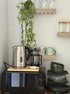 a kitchen with a coffee pot on top of a microwave at Avo 1 on 27 Drew in Howick