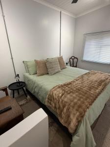 a bedroom with a large bed in a white room at Avo 1 on 27 Drew in Howick