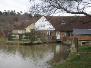 an old house next to a body of water at Bartley Mill in Wadhurst