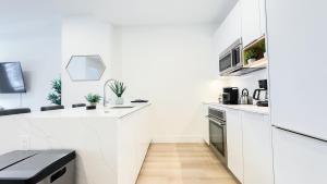 a kitchen with white walls and a counter top at Stylish 3BR Luxury Retreat in the Heart of FiDi in New York +10 photos