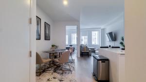 a white living room with a table and chairs at Stylish 3BR Luxury Retreat in the Heart of FiDi in New York
