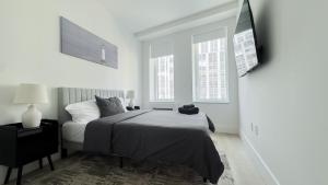 a bedroom with a bed and a flat screen tv at Stylish 3BR Luxury Retreat in the Heart of FiDi in New York