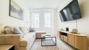 a living room with a couch and a flat screen tv at Stylish 3BR Luxury Retreat in the Heart of FiDi in New York