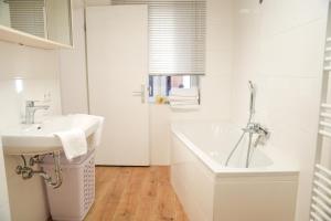 a white bathroom with a sink and a tub at Arber Lofts in Zwiesel in Zwiesel +33 photos