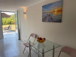 a dining room with a glass table with fruit on it at Alexandras Studio in Corfu +3 photos