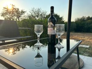 a bottle of wine and two glasses on a table at Alexandras Studio in Corfu