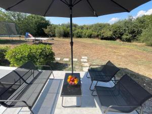 a table with a bowl of fruit and an umbrella at Alexandras Studio in Corfu