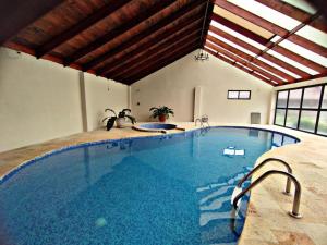 a large indoor swimming pool in a building at Blue Mountains Cabin in Boquete