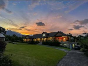 a large house with a sunset in the background at Blue Mountains Cabin in Boquete