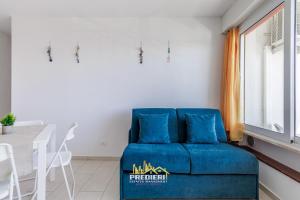 a blue couch in a living room with a table at Lido degli Estensi Fronte Mare e Balcone in Comacchio