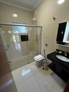 a bathroom with a shower and a toilet and a sink at Pousada e Restaurante Terra Rossa in São José do Rio Pardo +28 photos