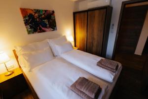 a bedroom with a white bed with two towels on it at U Stařečka in Hovorany +4 photos