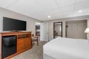 a bedroom with a bed and a flat screen tv at Best Western Plus Clocktower Inn in Billings
