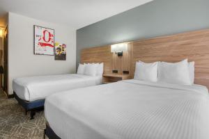 two beds in a hotel room with white sheets at Best Western Tomah Hotel in Tomah