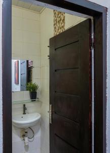 ein Badezimmer mit Holztür und Waschbecken in der Unterkunft La villa five star in Azuretti + 25 Fotos