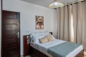 ein Schlafzimmer mit einem Bett, einer Tür und einem Fenster in der Unterkunft La villa five star in Azuretti