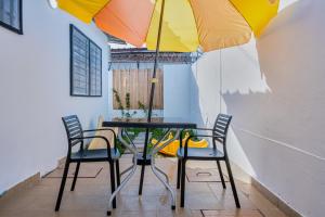 ein Tisch mit Stühlen und einem Sonnenschirm in einem Zimmer in der Unterkunft La villa five star in Azuretti