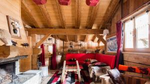 a living room with a red couch and a fireplace at Chalet La Grange à Germaine - Propriétés Mont Amour in Avoriaz