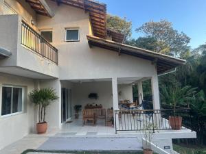 a house with a patio with a table and a balcony at veleiros g3 in Ibiúna
