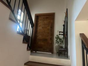 a hallway with a wooden door and a plant at veleiros g3 in Ibiúna +14 photos