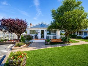 a house with a bench in a yard at Colonial Acres Resort in Yarmouth +8 photos