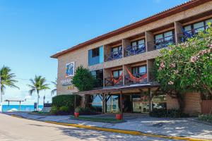a hotel on a street with the ocean in the background at Hotel Areias Belas in Maragogi