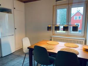 a kitchen with a table with chairs and a refrigerator at Schwedenhaus-Nykroppa in Nykroppa