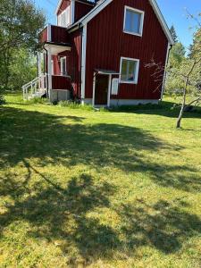a red house with a large yard in front of it at Schwedenhaus-Nykroppa in Nykroppa