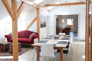 a dining room with a table and a red couch at Arber Lofts in Bayerisch Eisenstein in Bayerisch Eisenstein