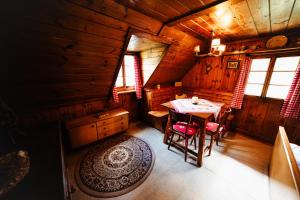 a room with a table and chairs in a cabin at Almhütte am Steirischen Seeberg in Turnau