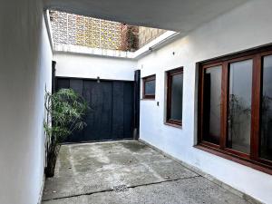 a garage with a black door and a plant at Casa amplia, céntrica y con garage en Junin, BA in Junín