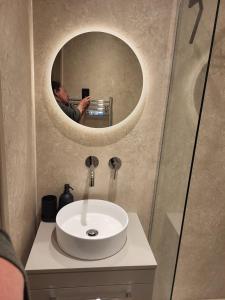 a man taking a picture of a sink in a bathroom at Holmleigh Place in Buxton