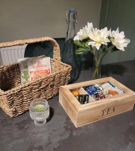 a table with two baskets and a box and flowers at Holmleigh Place in Buxton +2 photos