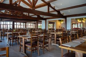 an empty restaurant with wooden tables and chairs at Guararema Parque Hotel in Guararema