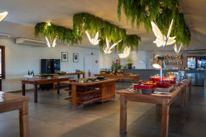 a restaurant with wooden tables and plants hanging from the ceiling at Guararema Parque Hotel in Guararema