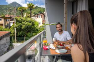 a man and a woman sitting at a table on a balcony at La Casetta di Cannero by Residenza La Zagara in Cannero Riviera