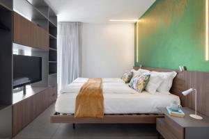 a bedroom with a bed and a flat screen tv at La Casetta di Cannero by Residenza La Zagara in Cannero Riviera
