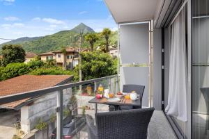 a balcony with a table and chairs and a view at La Casetta di Cannero by Residenza La Zagara in Cannero Riviera