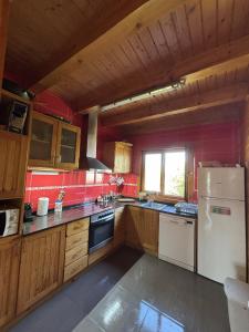 a kitchen with wooden cabinets and a white refrigerator at Casa Franch in Deltebre
