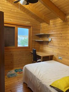 a bedroom with a bed and a desk and a window at Casa Franch in Deltebre