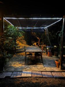 a picnic table under a pergola at night at Ca La Martona in Rubio de Dalt